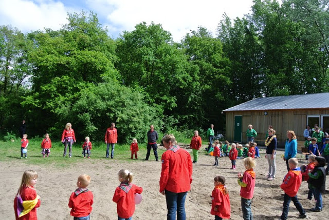 Bevers in rode blouses spelen samen op het scoutingterrein
