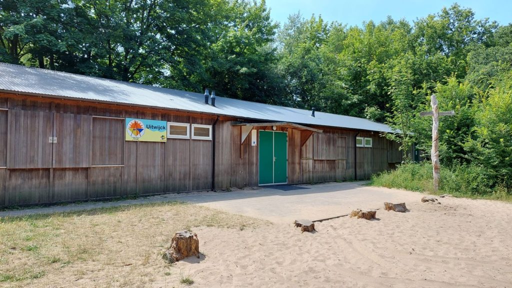 Het houten clubhuis Uitwijck tussen de bomen